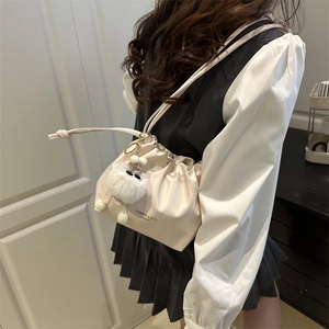 Chic off-white pleated cloud bag with drawstring and cute plush charm for women