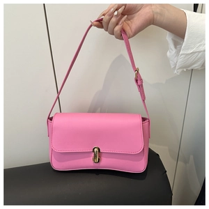 Detailed view of pink PU leather handbag featuring a golden swivel lock and adjustable strap
