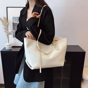 Minimalist creamy white large tote bag for women shown as worn on shoulder for commuting