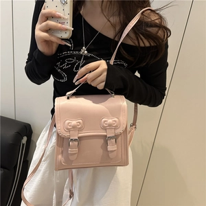 Pink minimalist crossbody backpack for women with decorative bow details and top handle