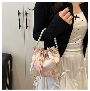 Detail of pink embroidered bucket bag with pearl handle and floral silk fabric