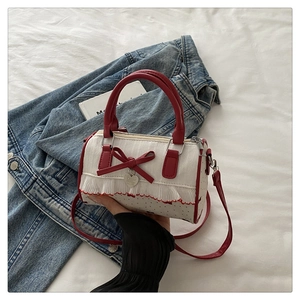 Detailansicht der gepunkteten Tasche mit roter Schleife und Spitzenbesatz auf Denim