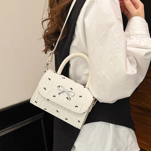 Sac bandoulière en cuir plissé blanc avec motifs de nœuds noirs et boucle argentée