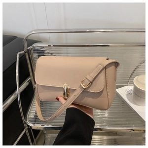 Close-up of elegant beige flap bag showing the polished golden twist-lock closure detail