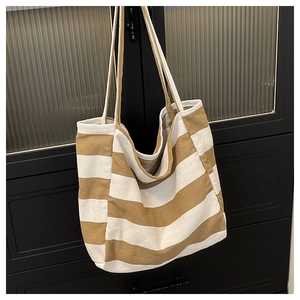 Close-up of thick striped canvas fabric and sturdy shoulder strap of the tote bag