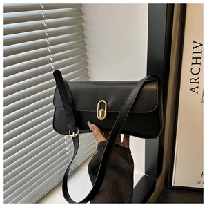 Close-up of black leather handbag featuring a stylish golden oval rotating metal buckle clasp