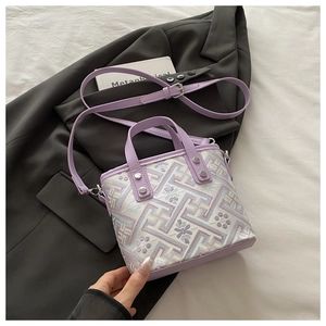 Detail of purple floral jacquard bucket bag with silver studs on leather trim