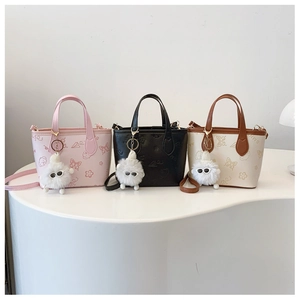 Detailed view of three mini bucket bags with embossed floral and puppy patterns