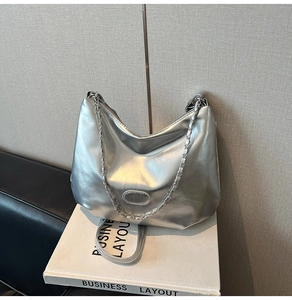 Detail showing metallic silver shoulder bag with chain strap and smooth faux leather finish