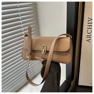 Detail of elegant khaki leather handbag featuring a polished gold oval twist lock closure
