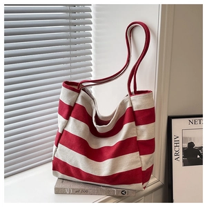 Detailed canvas texture of a large red and white striped tote bag on a white windowsill