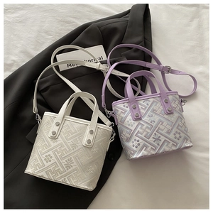 Close-up of geometric jacquard texture on tote bag with shoulder strap and handles