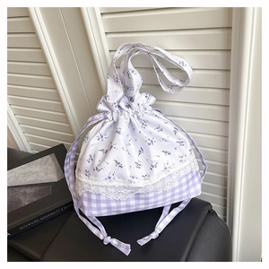 Detail of floral and plaid patchwork on drawstring bucket bag with lace trim