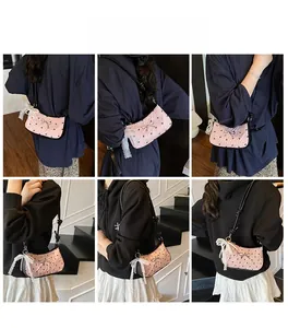 Pink quilted shoulder bag with black bows and lace details shown on a model