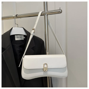 Detailed view of a white leather crossbody bag with a gold metal clasp on a hanger