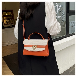 Dettaglio della borsa a tracolla con patchwork arancione e beige e chiusura a triangolo
