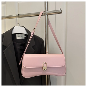 Close-up of pink leather underarm bag featuring a vintage gold metal twist lock buckle