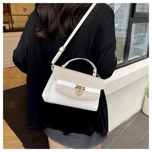 Dettaglio della borsa a tracolla bianca in ecopelle con patta intrecciata beige e chiusura