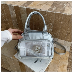 Detail of silver metallic tote bag with clear PVC pocket and adjustable shoulder strap