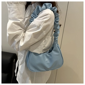 Detail of light blue crescent shoulder bag with a stylish pleated scrunchie strap
