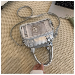 Detailed view of silver glossy PU bag with transparent window and metal zipper details