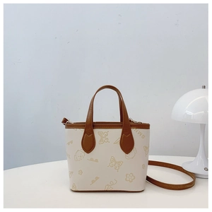 Detail of printed bucket bag showing dog and floral patterns on cream white surface