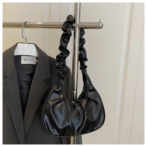 Detail of black ruched cloud bag showing soft glossy PU leather and unique pleated handle