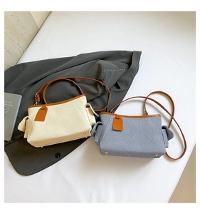 Detail of woven fabric and leather trim on retro handbags in beige and blue grey colors