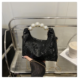 Detailansicht der schwarzen Tasche mit Schlangenmuster, Perlenhenkel und Goldkette