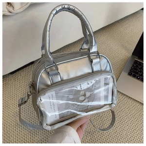 Macro detail of the silver metallic PU leather handbag featuring a clear front pocket