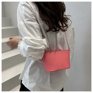 Detail der rosa Leder-Beuteltasche mit Logo-Prägung, getragen von Model auf weißer Treppe