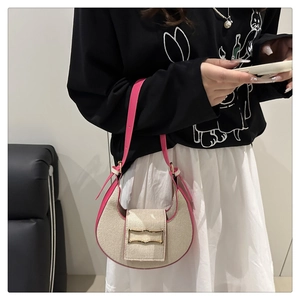 Detail of the woven texture and pink leather trim with golden buckle on the shoulder bag