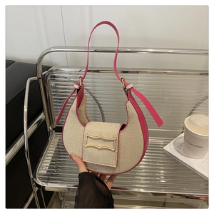 Close-up of hobo bag with beige woven fabric and vibrant fuchsia leather trim details