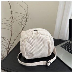 Détail du sac en velours côtelé beige avec double fermeture éclair et boucle de sangle noire