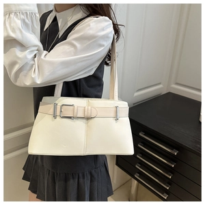 Detail of cream white shoulder bag with decorative belt strap and metal buckle