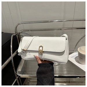 Détail du sac baguette en cuir blanc avec boucle en métal doré et fine bandoulière élégante