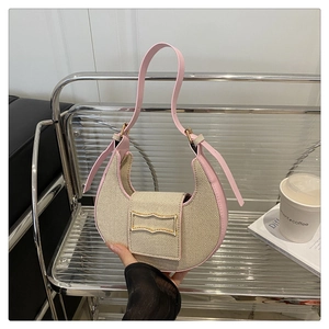 Detail of hobo shoulder bag with beige woven texture, pink trim, and golden wavy buckle