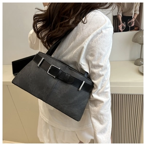 Detailed view of large grey matte shoulder bag with black belt strap and silver buckle