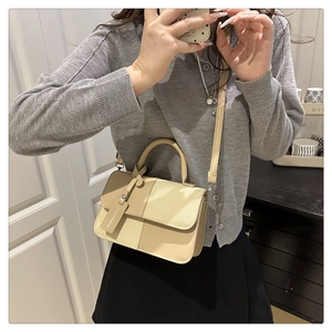 Close-up of beige patchwork handbag with Fashion & Bags tag and thin shoulder strap