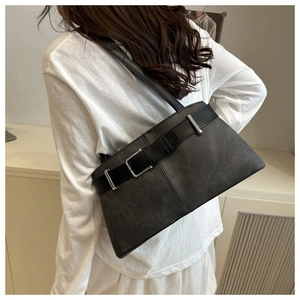 Detail of dark grey retro tote bag featuring a leather strap and silver metal buckle