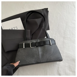 Detail of grey matte tote bag with black decorative belt and silver metal buckle