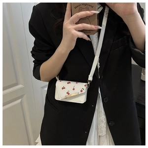Mini cherry print crossbody bag worn by model showing style and compact size