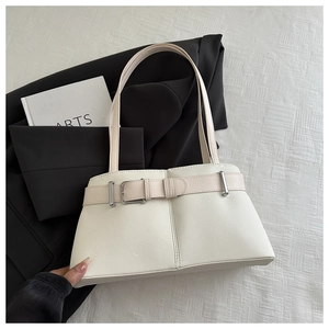Detail of cream leather tote bag featuring sleek belt buckle and minimalist shoulder straps