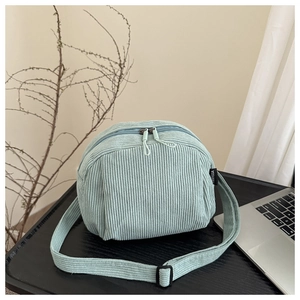 Détail du sac coquillage en velours côtelé bleu clair avec double zip et bandoulière