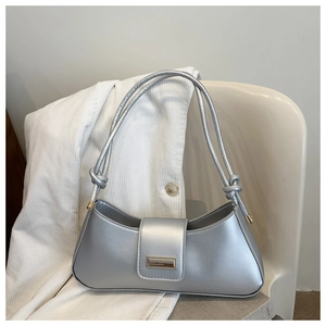 Detailed shot of silver half-moon shoulder bag with double knotted straps and metal buckle