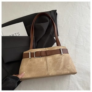 Detail of khaki suede underarm bag with brown leather strap and silver buckle accent