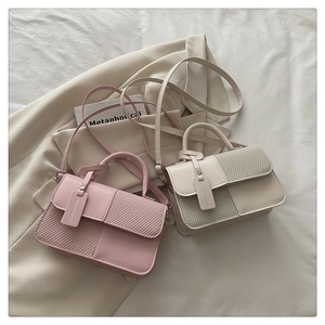 Dettaglio della trama intrecciata su borse a tracolla minimaliste rosa e beige