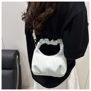 Detailed view of the marble texture faux leather and scrunchie handle on a crescent bag