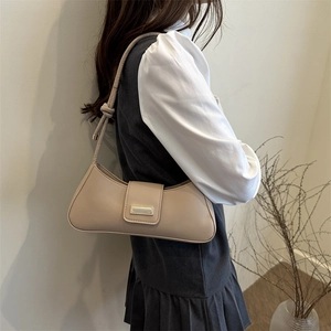 Minimalist beige baguette shoulder bag with gold buckle and knot strap detail for women