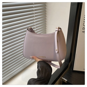 Détails du logo doré et des ferrures sur ce sac demi-lune de couleur lilas clair